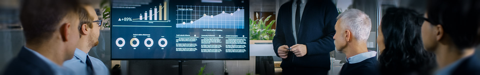 group of financial professionals having a meeting looking at a screen with financial graphs